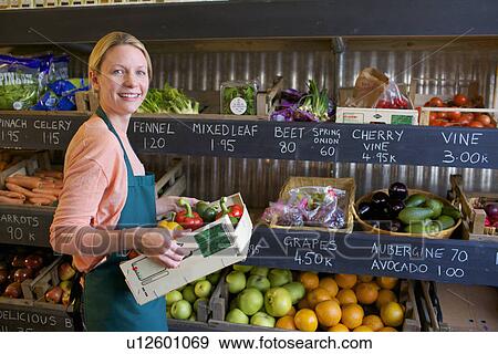 Grocer arranging produce for sale View Large Photo Image Stock Photo - Grocer arranging produce for sale. Fotosearch