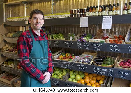 Grocer standing with produce for sale View Large Photo Image Stock Image - Grocer standing with produce for sale. Fotosearch