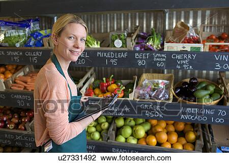 Grocer using tablet computer in store View Large Photo Image Stock Image - Grocer using tablet computer in store. Fotosearch