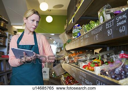 Grocer using tablet computer in store View Large Photo Image Stock Photography - Grocer using tablet computer in store. Fotosearch