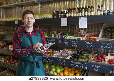 Grocer using tablet computer in store View Large Photo Image Stock Photography - Grocer using tablet computer in store. Fotosearch