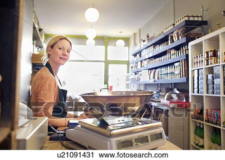 Grocer working behind counter at store View Large Photo Image Stock Image - Grocer working behind counter at store. Fotosearch