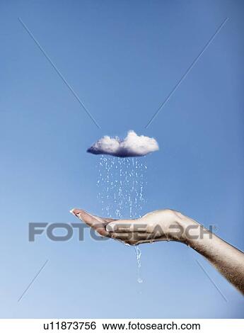 Stock Photograph - Hand holding pouring rain cloud. Fotosearch