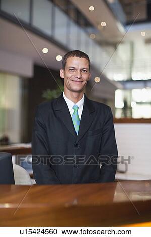 Hotel concierge smiling at desk View Large Photo Image Stock Image - Hotel concierge smiling at desk. Fotosearch