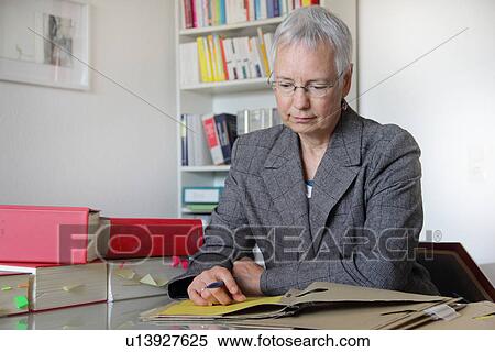 Stock Photography - Lawyer reading notes in office. Fotosearch