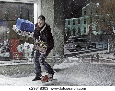 Man dropping Christmas gifts in snow View Large Photo Image Stock Image - Man dropping Christmas gifts in snow. Fotosearch