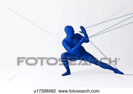 Stock Image - Man in bodysuit playing with string. Fotosearch