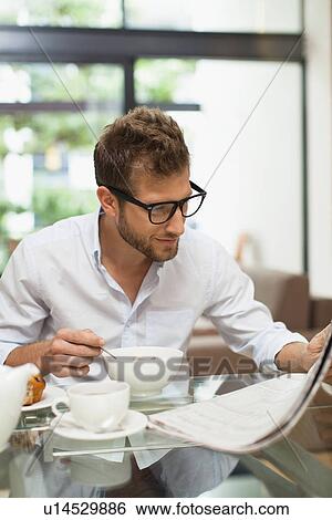Man reading newspaper at breakfast View Large Photo Image Stock Photograph - Man reading newspaper at breakfast. Fotosearch