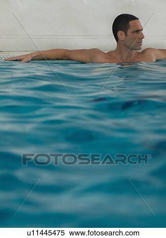 Stock Photography - Man relaxing in infinity pool. Fotosearch