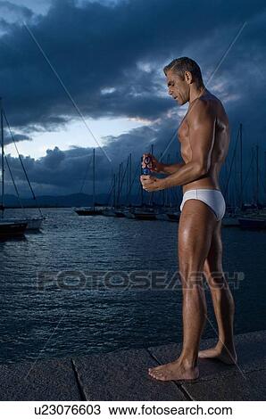 Stock Image - Man standing on pier. Fotosearch