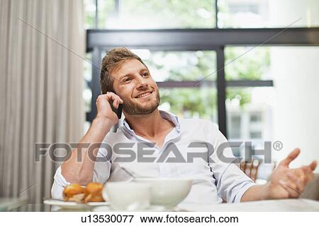 Man talking on cell phone at breakfast View Large Photo Image Stock Photo - Man talking on cell phone at breakfast. Fotosearch
