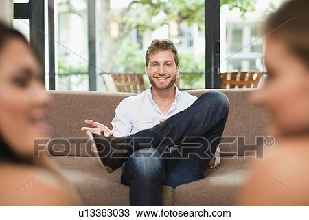Man talking to women on sofa View Large Photo Image Stock Image - Man talking to women on sofa. Fotosearch