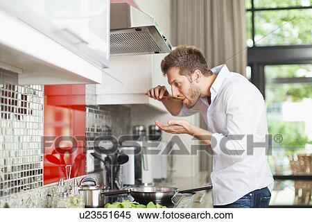 Man tasting food in kitchen View Large Photo Image Stock Photography - Man tasting food in kitchen. Fotosearch