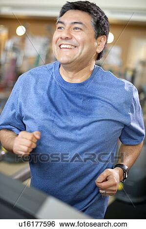Stock Photograph - Man using treadmill in gym. Fotosearch