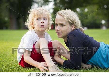 Stock Photo - Mother and son sitting in grass. Fotosearch