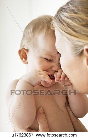 Mother holding smiling baby girl View Large Photo Image Stock Photo - Mother holding smiling baby girl. Fotosearch