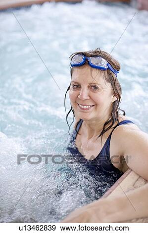 Stock Photo - Older woman relaxing in jacuzzi tub. Fotosearch