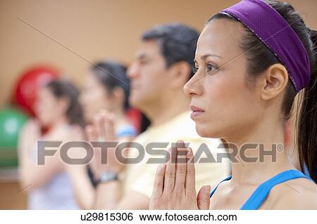 Stock Photograph - People practicing yoga in studio. Fotosearch
