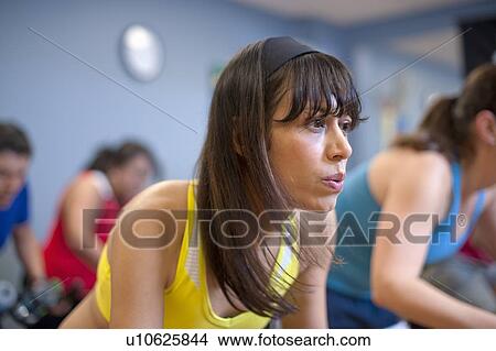Picture - People using spin machines in gym. Fotosearch