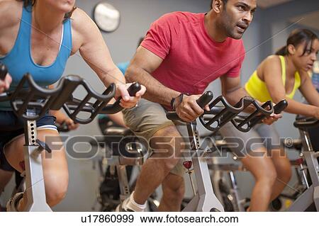 Stock Photo - People using spin machines in gym. Fotosearch
