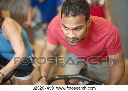 Stock Photo - People using spin machines in gym. Fotosearch