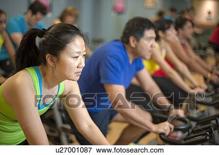 Stock Photo - People using spin machines in gym. Fotosearch