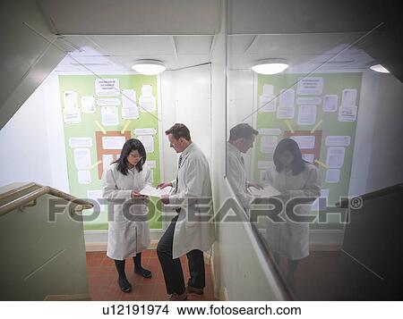 Picture - Science teacher discussing coursework with student. Fotosearch