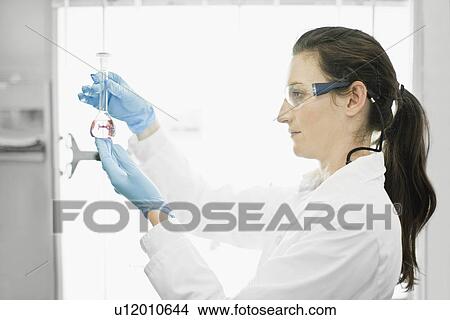 Scientist examining liquid in lab View Large Photo Image Picture - Scientist examining liquid in lab. Fotosearch
