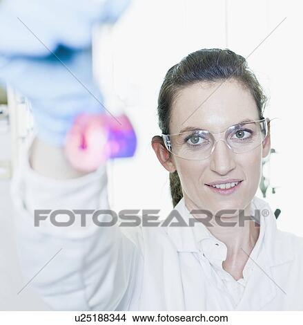 Picture - Scientist examining liquid in lab. Fotosearch