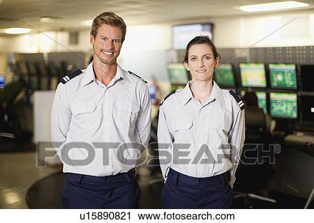 Stock Image - Security personnel in control room. Fotosearch