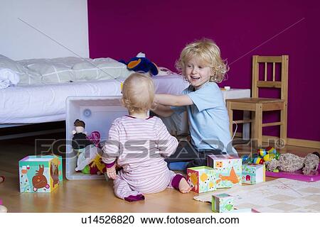 Siblings playing together in bedroom View Large Photo Image Stock Image - Siblings playing together in bedroom. Fotosearch