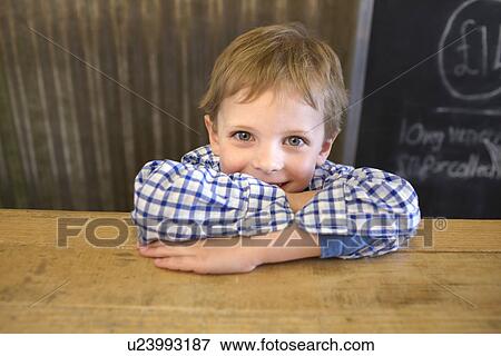 Smiling boy leaning on counter View Large Photo Image Stock Photo - Smiling boy leaning on counter. Fotosearch