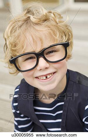 Smiling boy wearing glasses outdoors View Large Photo Image Stock Photography - Smiling boy wearing glasses outdoors. Fotosearch