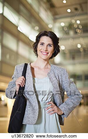 Stock Image - Smiling businesswoman with briefcase. Fotosearch