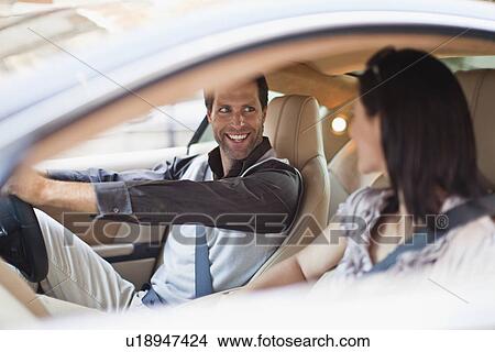 Picture - Smiling couple talking in sports car. Fotosearch