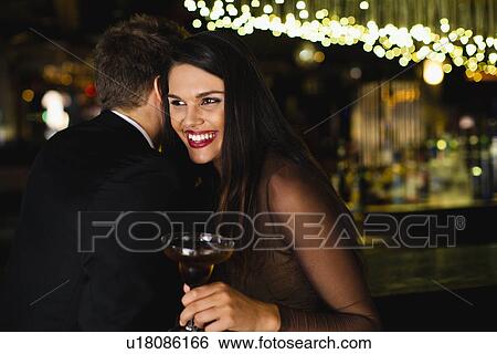 Stock Photograph - Smiling couple whispering at bar. Fotosearch