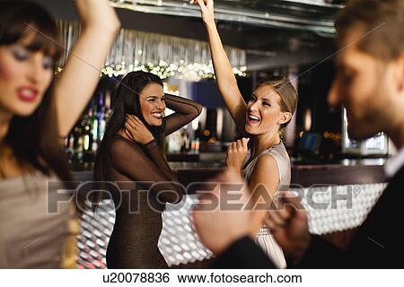 Smiling friends dancing in bar View Large Photo Image Stock Photograph - Smiling friends dancing in bar. Fotosearch