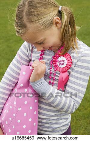 Smiling girl holding birthday present View Large Photo Image Stock Photo - Smiling girl holding birthday present. Fotosearch