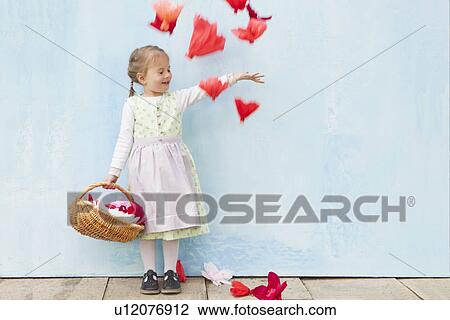 Stock Image - Smiling girl playing with paper flowers. Fotosearch