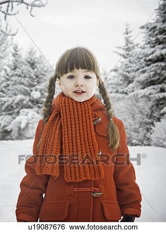 Stock Photograph - Smiling girl standing in snow. Fotosearch