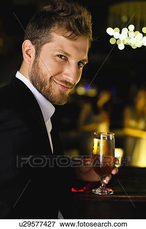Smiling man having drink at bar View Large Photo Image Stock Photo - Smiling man having drink at bar. Fotosearch