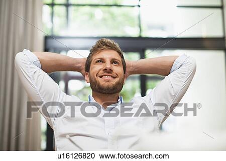 Smiling man relaxing in chair View Large Photo Image Stock Image - Smiling man relaxing in chair. Fotosearch