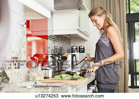 Smiling woman cooking in kitchen View Large Photo Image Stock Image - Smiling woman cooking in kitchen. Fotosearch