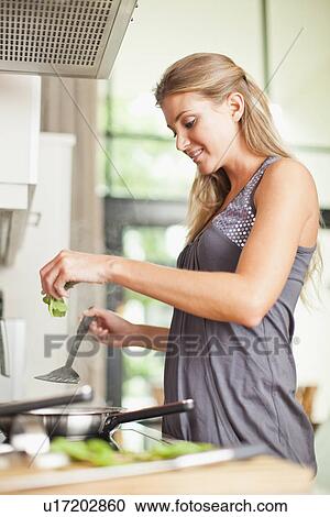Smiling woman cooking in kitchen View Large Photo Image Stock Image - Smiling woman cooking in kitchen. Fotosearch