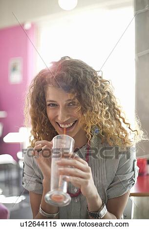 Stock Photography - Smiling woman drinking in cafe. Fotosearch