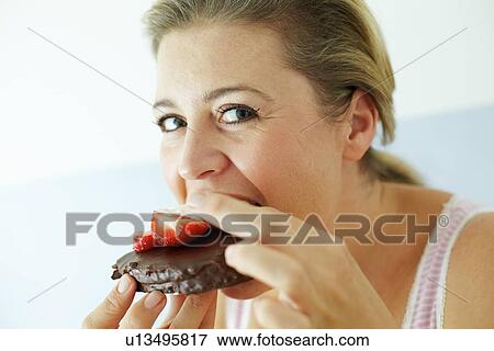 Smiling woman eating cake View Large Photo Image Stock Photo - Smiling woman eating cake. Fotosearch