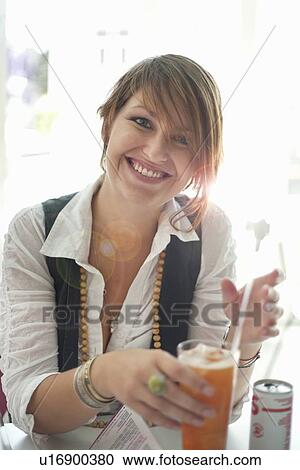 Stock Image - Smiling woman having glass of soda. Fotosearch