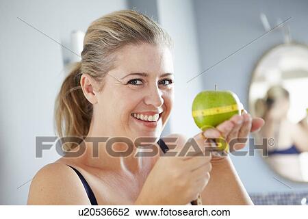 Smiling woman measuring apple View Large Photo Image Stock Image - Smiling woman measuring apple. Fotosearch