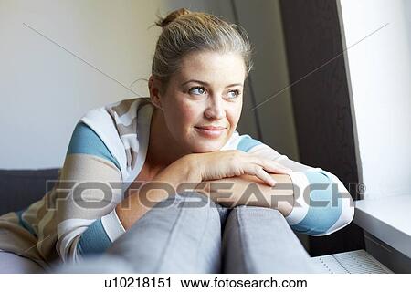 Smiling woman relaxing on sofa View Large Photo Image Stock Image - Smiling woman relaxing on sofa. Fotosearch