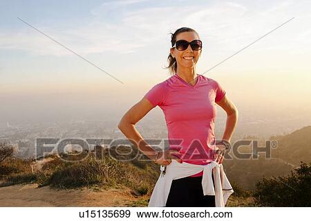 Smiling woman standing on hilltop View Large Photo Image Stock Photo - Smiling woman standing on hilltop. Fotosearch